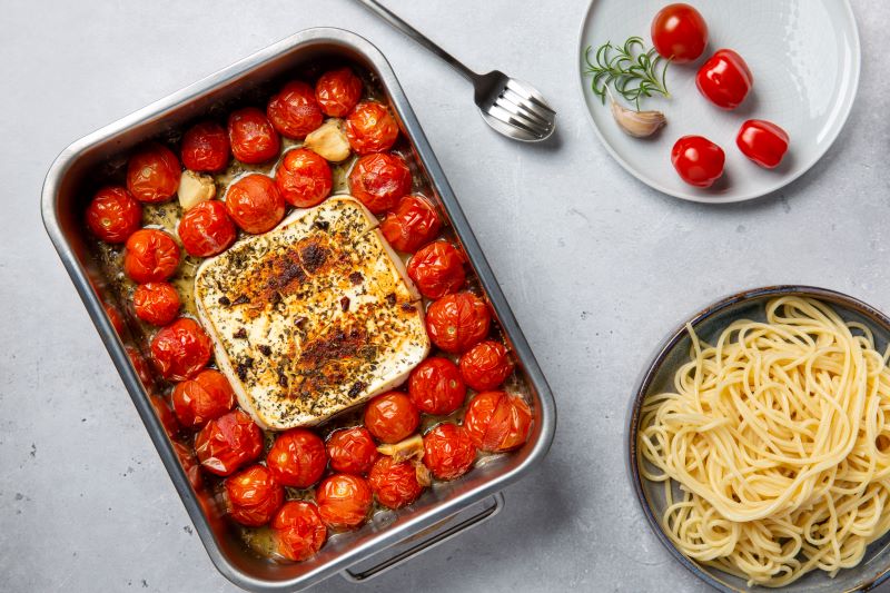 Vegan Baked TikTok Feta Pasta in Baking Pan with Plate of Spaghetti on Gray Countertop | Vitacost.com/blog