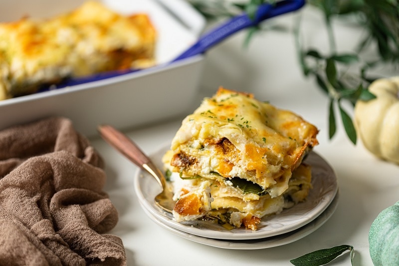 A Slice of Homemade Meatless Butternut Squash Lasagna on Plate Next to Casserole Dish | Vitacost.com/Blog