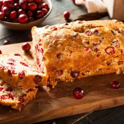 Gluten-Free Cranberry Orange Bread With Nuts on Wood Cutting Board | Vitacost.com/blog
