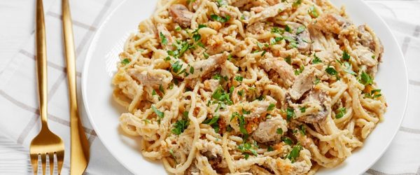 A White Plate With Creamy Pasta, Shredded Turkey and Fresh Herbs Represent Leftover Turkey Casserole | Vitacost.com/Blog