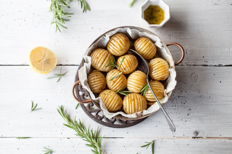 Coconut Curry Hasselback Potato Recipe in Serving bowl with Rosemary | Vitacost.com/blog