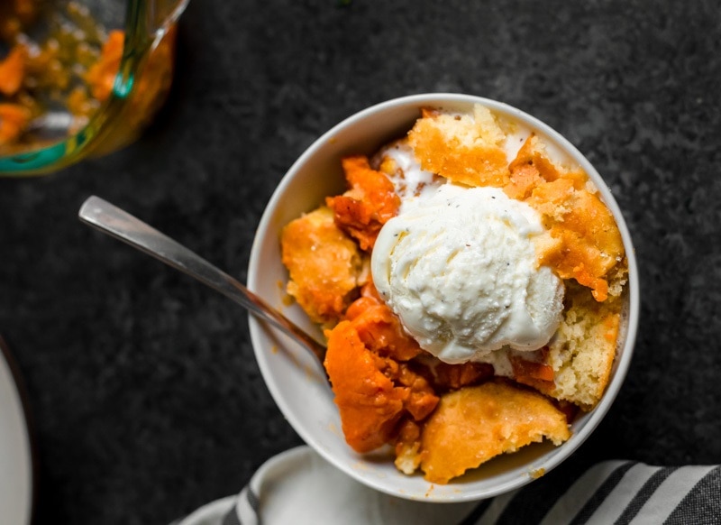 Sweet Potato Cobbler in a White Bowl With a Scoop of Vanilla Ice Cream | Vitacost.com/Blog