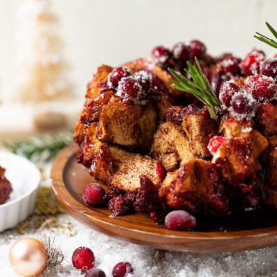 Homemade Cranberry-Glazed Monkey Bread Garnished with a Rosemary Sprig on Cake Stand | Vitacost.com/Blog