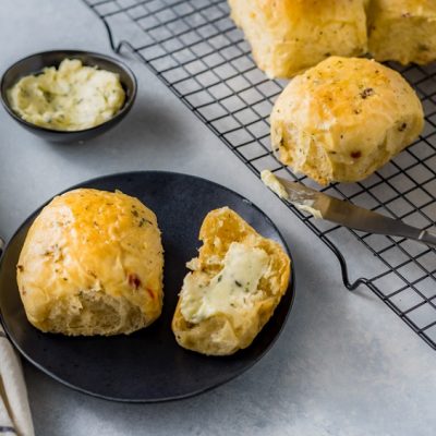 Homemade Olive Bread Dinner Rolls on Plate Next to Batch on Cooling Rack | Vitacost.com/Blog