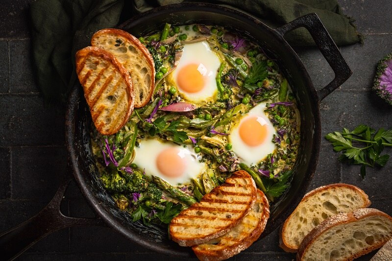 Green Shakshuka in a Skillet With Three Poached Eggs and Four Slices of Grilled Toast | Vitacost.com/Blog