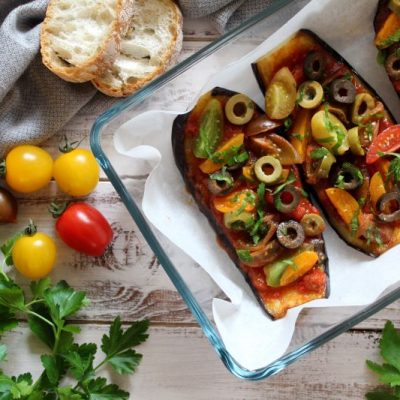 Stuffed Eggplant Boats with Olives, Tomatoes and Marinara in Baking Dish on Wooden Table | Vitacost.com/blog