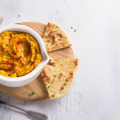 Homemade Turmeric Hummus Garnished with Olive Oil and Paprika with Pita Bread | Vitacost.com/Blog