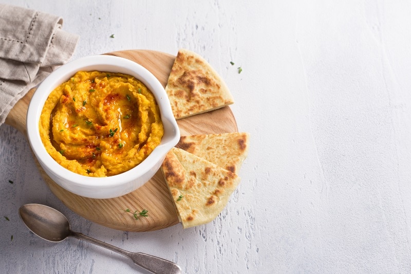 Homemade Turmeric Hummus Garnished with Olive Oil and Paprika with Pita Bread | Vitacost.com/Blog