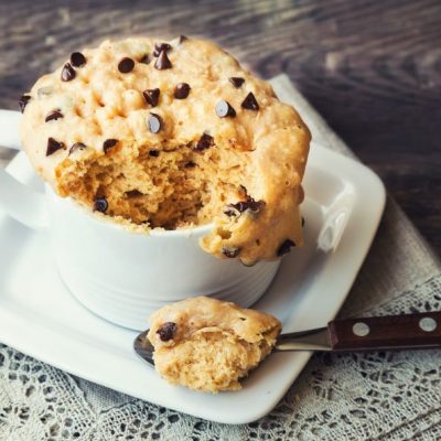 Chocolate Chip Mug Cake for One in White Mug with Spoon on Lace-Edged Napkin | Vitacost.com/blog