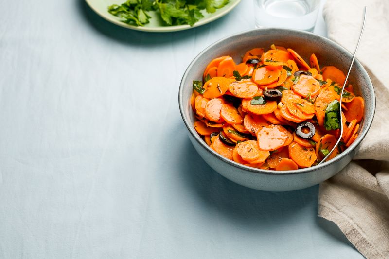 Moroccan Carrot Salad With Olives in Stoneware Bowl on Tabletop | Vitacost.com/blog