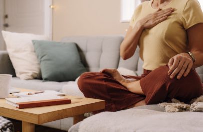 Stress and Heart Health Represented by Woman With Hand Over Chest on Couch | Vitacost.com/blog