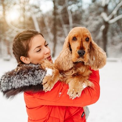 Woman Holding Dog Outside in Snow | Vitacost.com/Blog