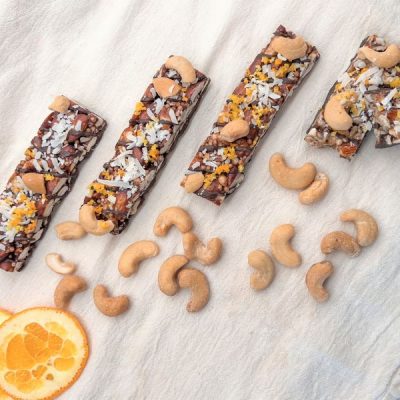 Cashew & Coconut Energy Bars with Orange Zest on White Cotton Kitchen Towel with Orange Slices | Vitacost.com/blog