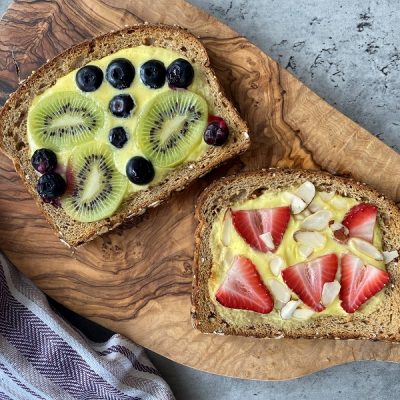 Homemade Custard Yogurt Toast Topped with Blueberries, Strawberries, Kiwi and Slivered Almonds on Wooden Cutting Board | Vitacost.com/Blog