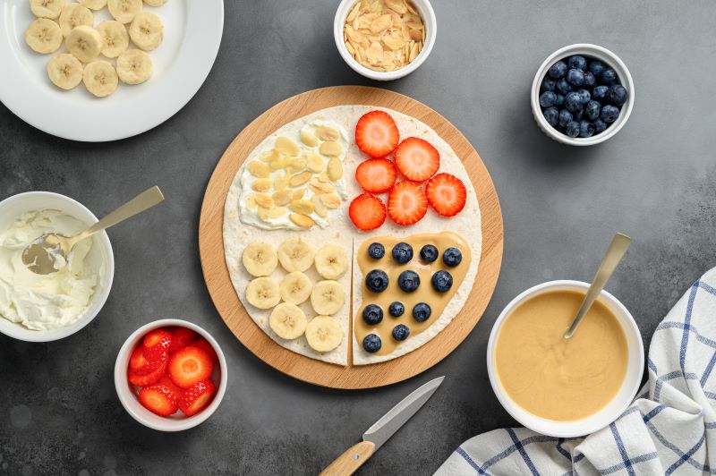 Vegan Cream Cheese & Fruit Tortilla Wrap Flat-Lay Shot with Fruit on Gray Counter | Vitacost.com/blog