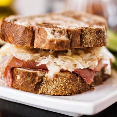 Homemade Vegan Reuben Sandwich with Plant-Based Meat, Dairy-Free Cheese, Sauerkraut and Russian Dressing on White Plate | Vitacost.com/Blog