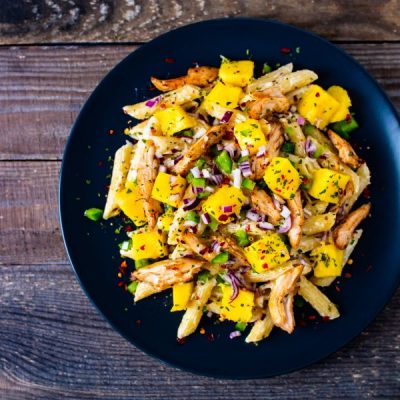 Plant-based ragu pasta made with jackfruit and mango on black plate atop wood table | Vitacost.com/blog