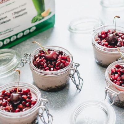 Vegan Cheesecake in a Jar with Pomegranate Seeds & Cherries on Top on White Counter | Vitacost.com/blog