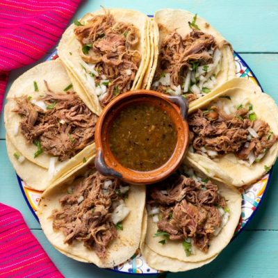 Lamb barbacoa tacos on plate with turquoise background | Vitacost.com/blog