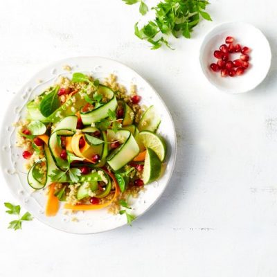 Quinoa salad with cucumber and carrot ribbons and pomegranate seeds on white plate | Vitacost.com/blog