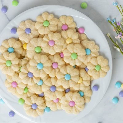 A Plate Filled With Dainty Flower Sugar Cookies Surrounded by Pastel-Colored Candies to Represent Cookies for Easter | Vitacost.com/Blog
