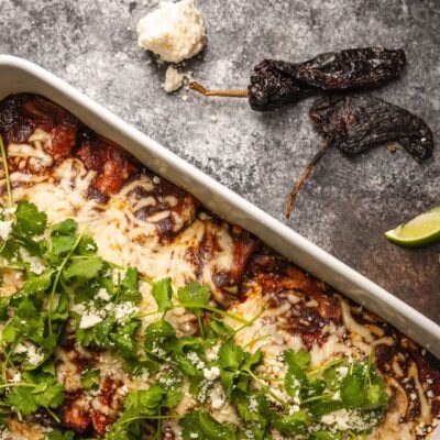 Vegetable mole enchiladas in baking dish with cheese and cilantro on top | Vitacost.com/blog