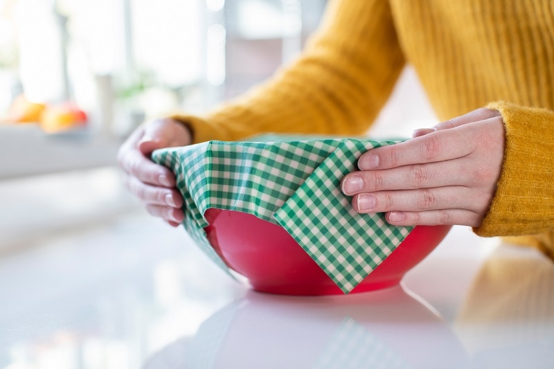 Person Securing Reusable Food Storage Wrap on Top of Bowl with Leftovers | Vitacost.com/Blog