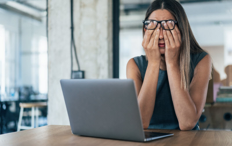 Woman With Computer Vision Syndrome at Desk with Laptop Rubbing Eyes | Vitacost.com/blog