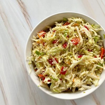Crunchy Ramen Salad with Cabbage and Red Bell Pepper in White Round Bowl on Marble Countertop | Vitacost.com/blog
