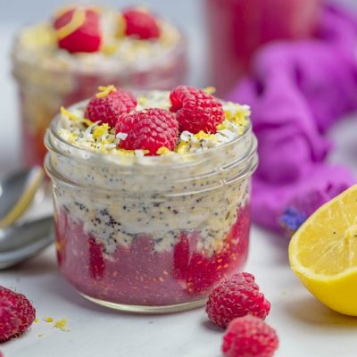 A Small Mason Jar is Filled With Layers of Bright Red Raspberry Jam and Lemon-Poppy Overnight Oats to Represent Lemon Poppy Seed Overnight Oats | Vitacost.com/Blog