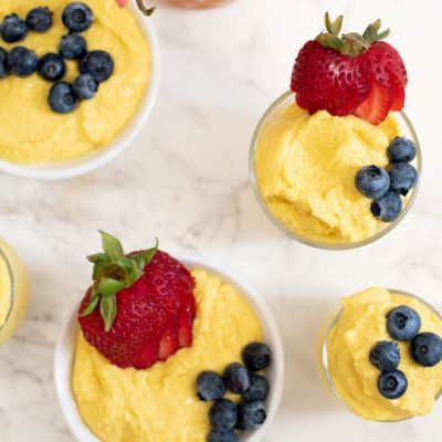 Mango Mousse in Several Cups & Bowls Topped with Blueberries & Strawberries all Sett on a Marble Countertop | Vitacost.com/blog