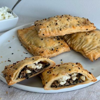 Spinach, Feta & Mushroom Pies Sprinkled with Sunflower Seeds atop White Plate | Vitacost.com/Blog