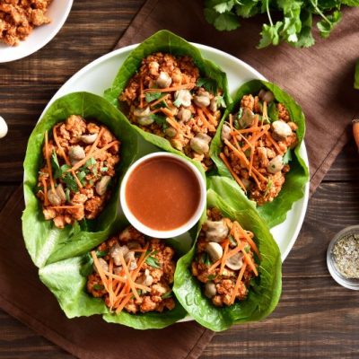Chicken Lettuce Wraps on Serving Plate With Sauce Bowl in Center on Wood Tabletop | Vitacost.com/blog