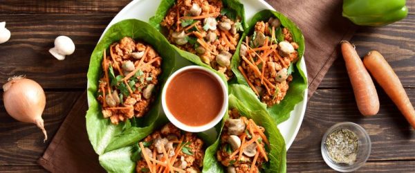 Chicken Lettuce Wraps on Serving Plate With Sauce Bowl in Center on Wood Tabletop | Vitacost.com/blog