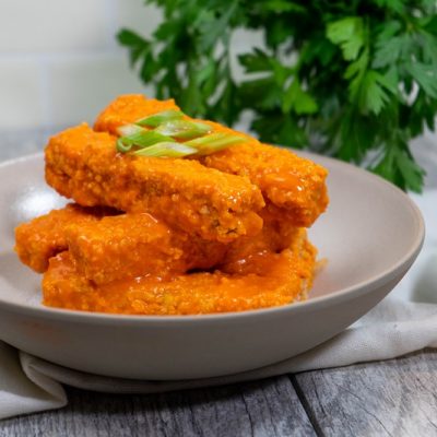 Homemade Vegan Buffalo Tofu Strips in Bowl Garnished with Green Onion | Vitacost.com/Blog