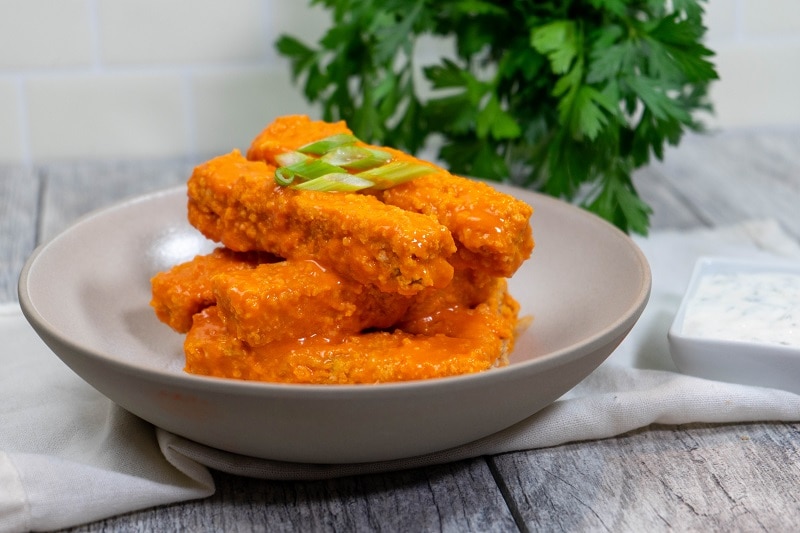 Homemade Vegan Buffalo Tofu Strips in Bowl Garnished with Green Onion | Vitacost.com/Blog