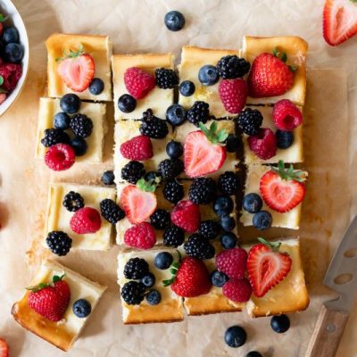 Cheesecake Bars Topped With Berries Sliced into Squares on Parchment Paper | Vitacost.com/Blog