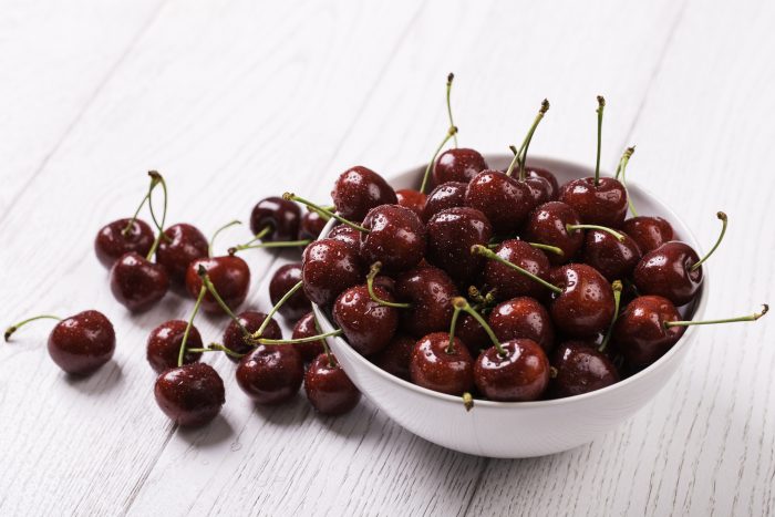 White Bowl on White Background Overflowing with Fresh Cherries | Vitacost Blog