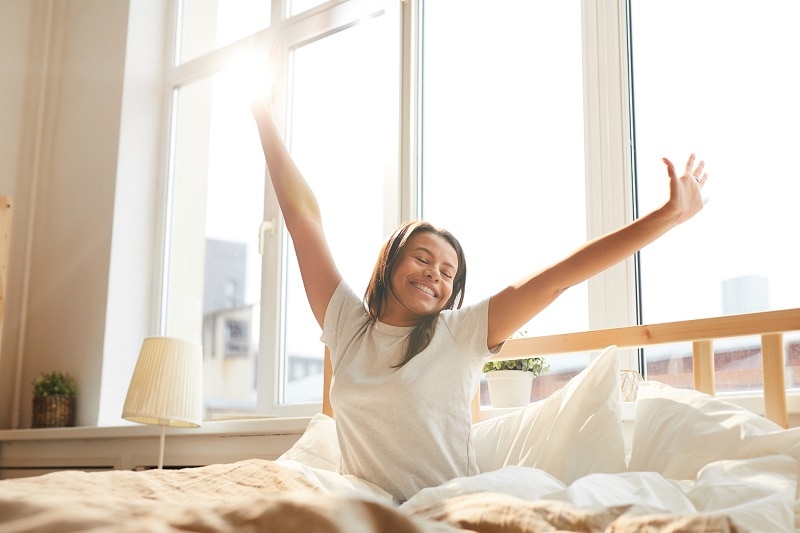 Woman Waking Up in the Morning in Bed After a Night of Healthy Sleep | Vitacost.com/Blog