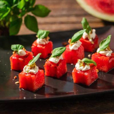 Grilled Watermelon & Goat Cheese With Basil & Nuts on Serving Plate