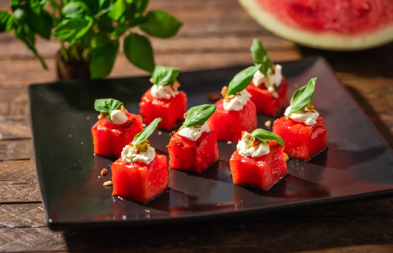 Grilled Watermelon & Goat Cheese With Basil & Nuts on Serving Plate