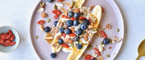 Homemade Breakfast Banana Split Topped with Greek Yogurt, Nuts, Seeds and Berries on Plate | Vitacost Blog