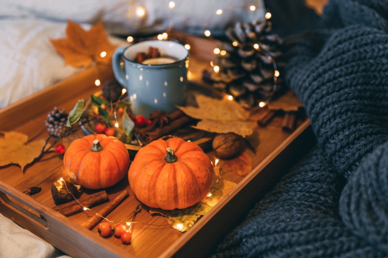 Autumn Setting with Tray Filled With Pumpkins, Leaves and Mug of Tea