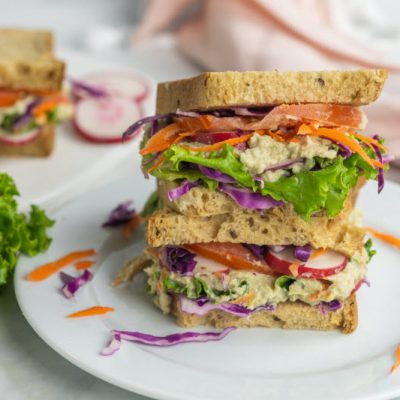Artichoke White Bean Vegetarian Sandwich Sitting On A White Plate.
