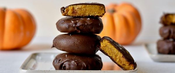 Chocolate-Dipped Vegan Pumpkin Cookies on Serving Plate on a Table in Front of Pumpkins
