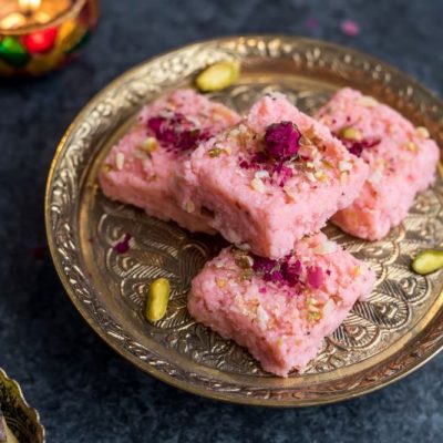 Rose Kalakand: Indian Milk Cake on Etched Brass Platter with Scattered Pistachio Nuts
