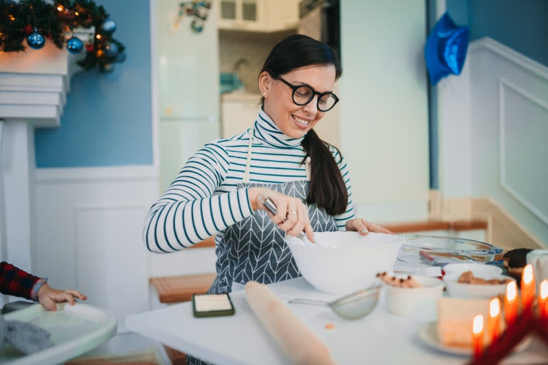 Woman Avoiding Holiday Burnout Happily Baking Cookies in Kitchen