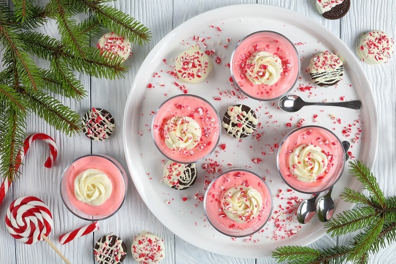 An Overhead Shot Shows a Round White Plate With Four Pink Peppermint Vegan Mousse Cups.