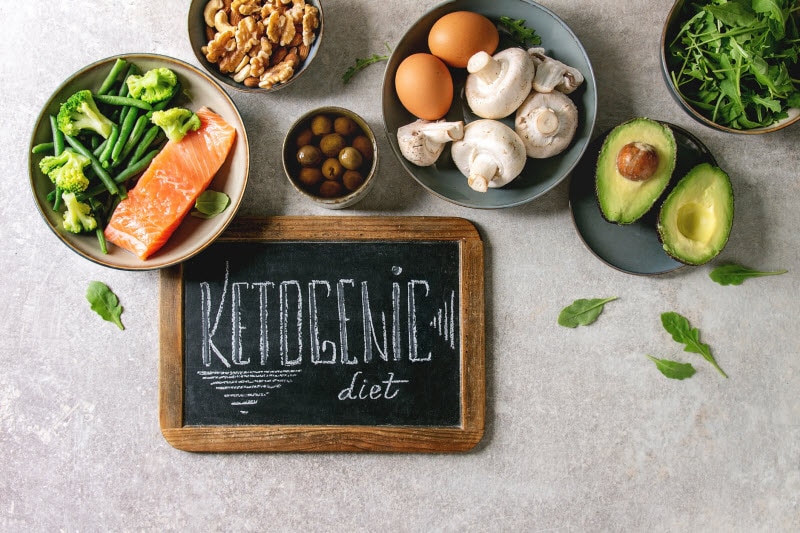 Keto Diet Weight Loss Concept Represented by Keto Foods and Chalkboard on Marble Surface