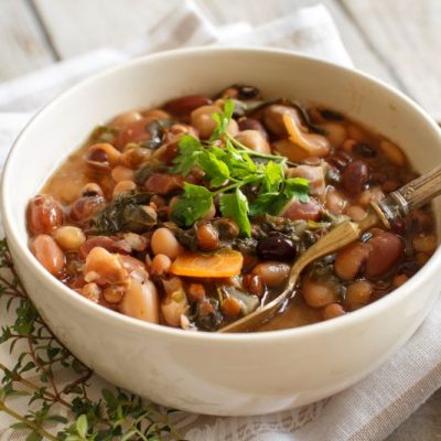 Greens and Beans Veggie Stew in Bowl on Wooden Table